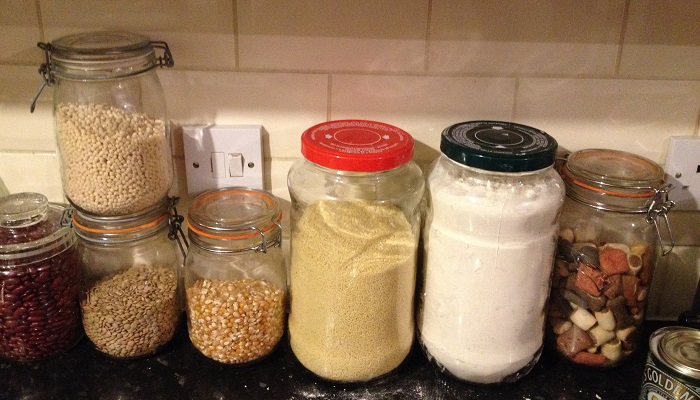 Glass jars of pulses and other bulk items on a kitchen bench