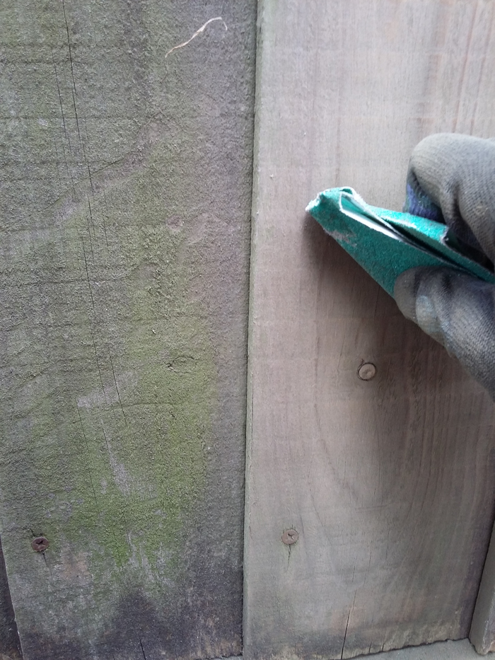 Rubbing down the fence with sandpaper