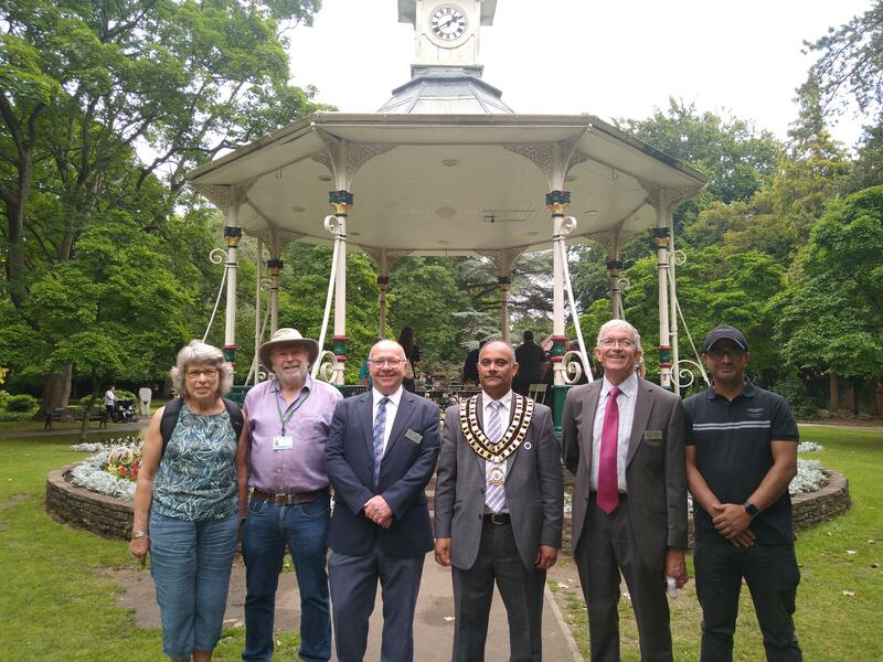 The Swindon mayor, judges, and parish council staff pose by the Town Gardens band stand