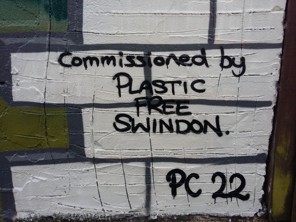 A section of painted cutaway bricks in the mural reads, 'Commissioned by Plastic Free Swindon' and is signed by Peter Cowdy 2022