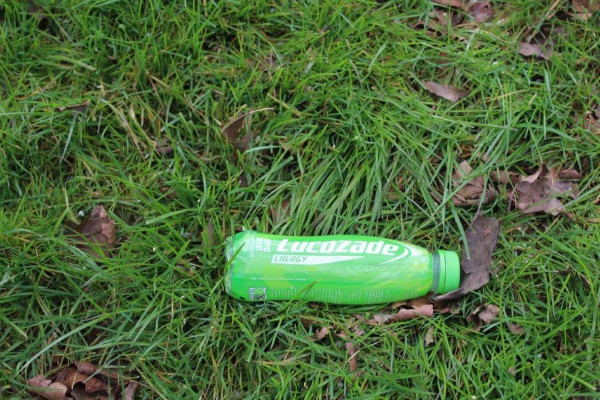 Plastic Lucozade bottle littered on an area of grass