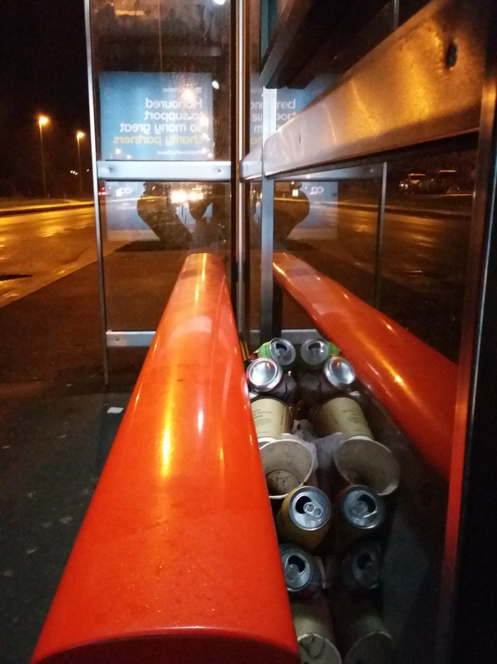 Drinks cans stuffed down the back of a bus stop seat