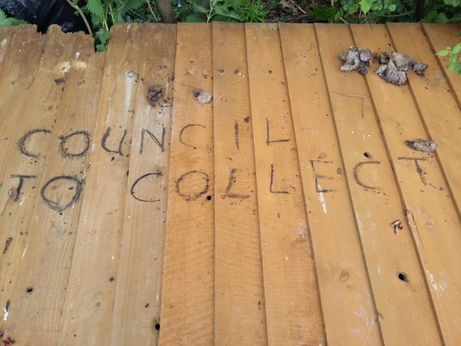 'Council to collect' written on a fence panel with charcoal