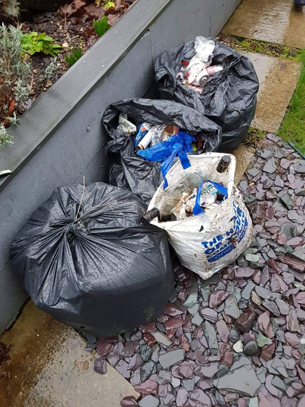 A collection of rubbish bags on a path