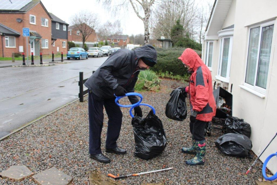 Litter pickers tie up bag and take off the hoop to put on another