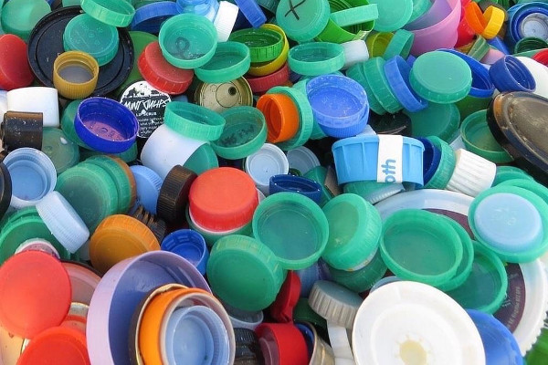 A large pile of HDPE bottle tops of varied sizes and colours