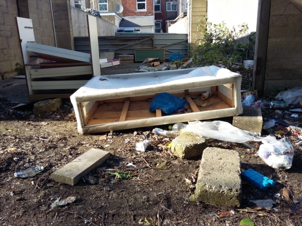 Heavy flytipping and littering at the back of house in an alleyway