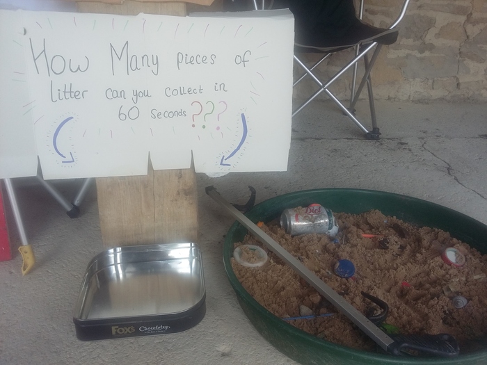 Sandpit with a sign that reads:'How many pieces of litter can you collect in 60 seconds?'