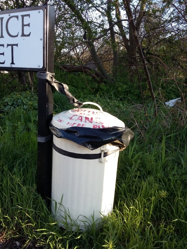 Community bin tied to a road sign