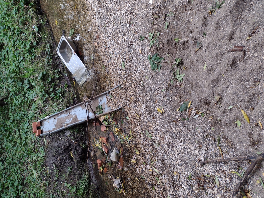 A slide and kitchen sink discarded in the river