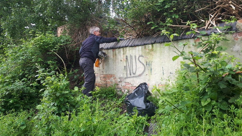 Removing rubbish from behind a wall