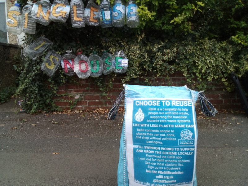 Display in a hedge made from reused plastic which reads, 'Single use is no use'