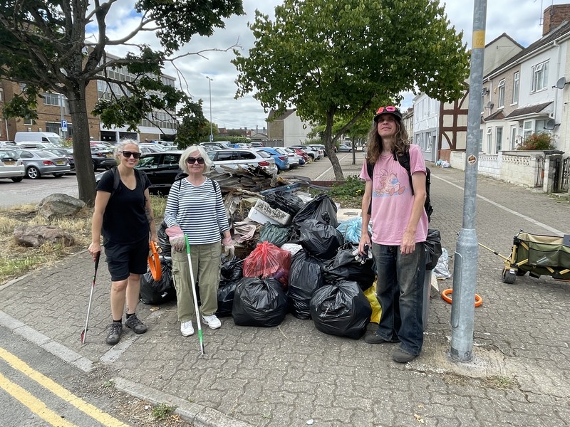 3 litter pickers stand by big pile of collected rubbish