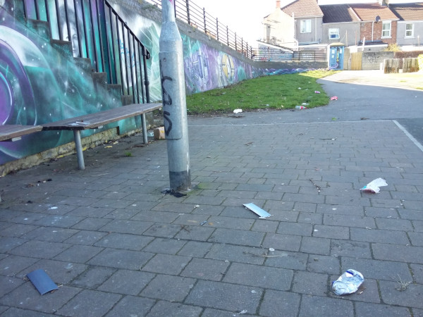 Various items of litter by a bench in a playparks