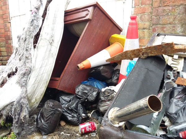 Flytipping including a mattress, chair, and wooden furniture